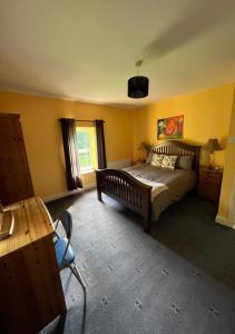 a bedroom with a bed and a table and a chair at The Rathmore House in Roscommon