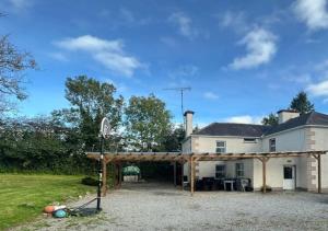 una casa con un pabellón delante de ella en The Rathmore House, en Roscommon