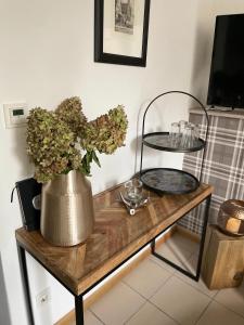 einen Tisch mit einer Blumenvase drauf in der Unterkunft Weberhof Apartment 2 in Münster