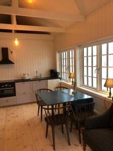 a kitchen with a table and chairs in a room at Agundaborg boathouse close by lake in Agunnaryd