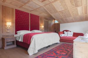 a bedroom with a large bed and a red headboard at Hotel La Perla: The Leading Hotels of the World in Corvara in Badia