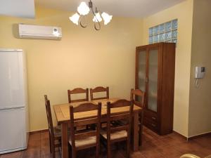 a dining room with a table and chairs and a refrigerator at El rincon de los enebros in Ruidera
