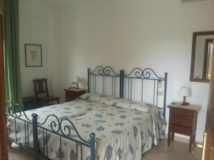 sypialnia z łóżkiem z niebiesko-białą kołdrą w obiekcie Agriturismo La Mancosa w mieście Pollica