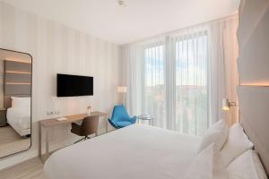 um quarto de hotel com uma cama, uma secretária e uma janela em Avani Rio Novo Venice Hotel - previously NH Venezia Rio Novo em Veneza