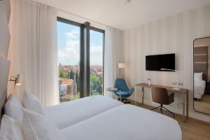 ein Hotelzimmer mit einem Bett und einem großen Fenster in der Unterkunft Avani Rio Novo Venice Hotel - previously NH Venezia Rio Novo in Venedig