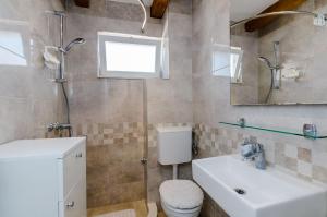 a bathroom with a sink and a toilet and a mirror at Apartment Marina View in Dubrovnik