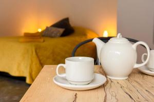a table with two cups and a tea pot on it at Sharp Tor Riverside Studio Apartment in Plymouth