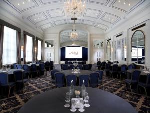 a ballroom with tables and chairs and a projection screen at Castle Hotel Windsor in Windsor