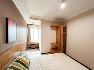 een kleine slaapkamer met een bed en een raam bij Galeri Ciumbuleuit Apartment 1 2BR 1BA - code 12B in Bandung