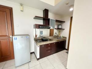 een keuken met een koelkast en een wastafel bij Galeri Ciumbuleuit Apartment 1 2BR 1BA - code 12B in Bandung