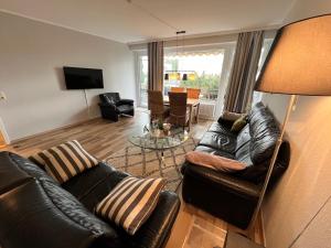 un salon avec des meubles en cuir et une table dans l'établissement Prinzenhof, Whg 2, à Grömitz