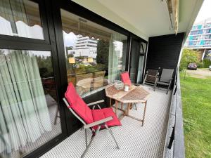 d'une terrasse avec des chaises rouges et une table sur un balcon. dans l'établissement Prinzenhof, Whg 2, à Grömitz