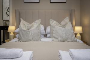 a bed with white pillows on top of it at The Blackpool Beach Boutique Apartments in Blackpool