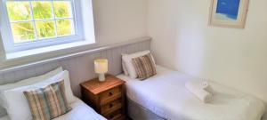 2 łóżka pojedyncze w pokoju z oknem w obiekcie Tregenna Castle Resort w St Ives