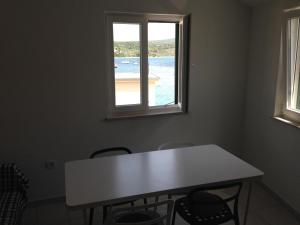 a white table and chairs in a room with a window at Villa Neka in Primošten