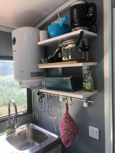 a kitchen with a sink and a mixer and shelves at Agundaborg Lake hut with a view in Agunnaryd +13 photos