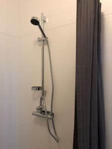 a shower head on a wall next to a curtain at Agundaborg Lake hut with a view in Agunnaryd