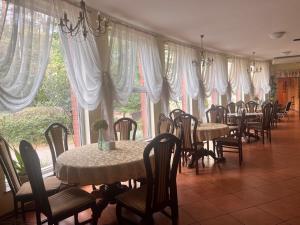 een eetkamer met tafels, stoelen en ramen bij HOTEL MOTEL S5 in Bydgoszcz