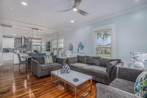 a living room with a couch and a table at Luxury Designer Villa by the Beach Bright Beautiful Brand New in Galveston