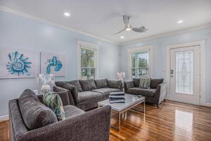 a living room with two couches and a table at Luxury Designer Villa by the Beach Bright Beautiful Brand New in Galveston