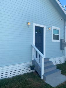 a blue house with a staircase leading to a door at Luxury Designer Villa by the Beach Bright Beautiful Brand New in Galveston