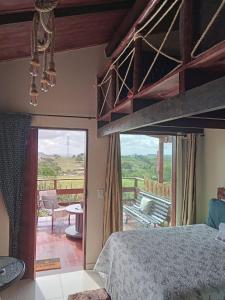 a bedroom with a bunk bed and a balcony at Chalé Adventure in Serra de São Bento