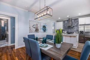 a dining room with a wooden table and blue chairs at Luxury Designer Villa by the Beach Bright Beautiful Brand New in Galveston