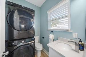 a washing machine in a bathroom with a sink at Luxury Designer Villa by the Beach Bright Beautiful Brand New in Galveston
