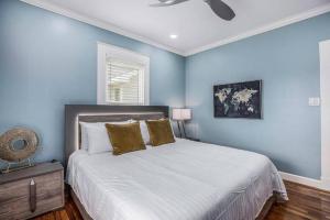 1 dormitorio con 1 cama grande y paredes azules en Luxury Designer Villa by the Beach Bright Beautiful Brand New en Galveston