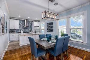 a dining room with a table and blue chairs at Luxury Designer Villa by the Beach Bright Beautiful Brand New in Galveston