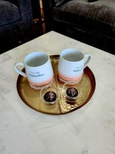 two coffee mugs on a tray on a table at Luxury Designer Villa by the Beach Bright Beautiful Brand New in Galveston