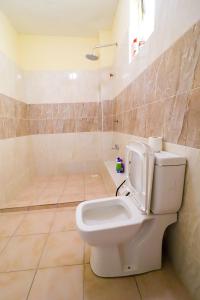 a bathroom with a toilet and a tub at LES INTERNATIONAL in Mombasa
