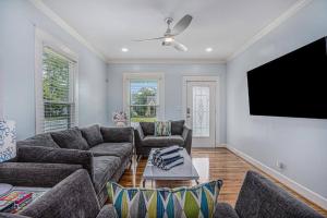 a living room with a couch and a flat screen tv at Luxury Designer Villa by the Beach Bright Beautiful Brand New in Galveston