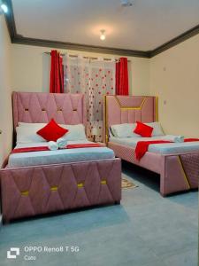 two beds in a room with red and pink at LES INTERNATIONAL in Mombasa