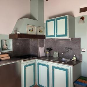 una cocina con armarios azules y fregadero en Le Case Gialle, en Gualdo Cattaneo