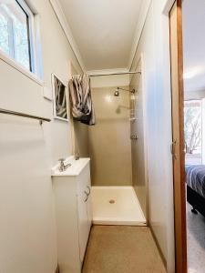 a small bathroom with a shower and a sink at Karratha Village Workforce Accommodation in Karratha