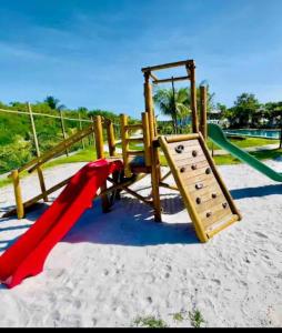 a playground with a slide in the sand at INCRIVEL apartamento com vista lago! in Praia do Forte