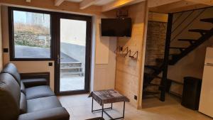 a living room with a couch and a tv and a staircase at Le Toit du Cambre d'Aze in Saint-Pierre-dels-Forcats