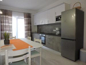 a kitchen with a table and a refrigerator at Pansion Berat in Vodnjan