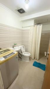ein weißes Bad mit einem WC und einem Waschbecken in der Unterkunft Puncak Bukit Golf Apartemen in Surabaya