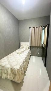 ein kleines Schlafzimmer mit einem Bett in einem Zimmer in der Unterkunft Puncak Bukit Golf Apartemen in Surabaya