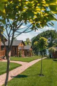 uma casa com uma árvore em frente a uma passarela em СИНІ ВОДИ база відпочинку 