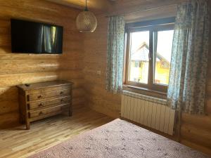 Habitación con TV, tocador y ventana. en Karpaty, en Yaremche