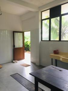 sala de estar con mesa y puerta en New Stay Inn, en Bentota
