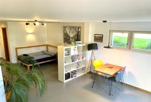 a bedroom with a bed and a desk and a table at Helle Souterrain Wohnung in Laufnähe zum Wörthsee in Wörthsee