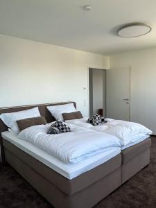 Cama grande en habitación con 2 camas individuales en Sonnige Wohnung mit schöner Aussicht in Wolfurt en Wolfurt