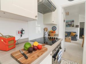 a kitchen counter with a cutting board with fruit on it at Mackerel Sky in Marazion