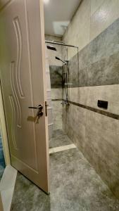 a bathroom with a shower and a door at Twins in Tbilisi City