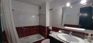 a bathroom with a sink and a toilet and a mirror at Las Moreras Playa Blanca in Playa Blanca