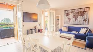 sala de estar con mesa blanca y sofá azul en La Terrazza sul Lago - Italian Homing, en Polpenazze del Garda